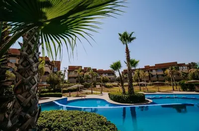 a resort with a palm tree and a swimming pool at Spacious 3BR with Prime Location in Marrakech