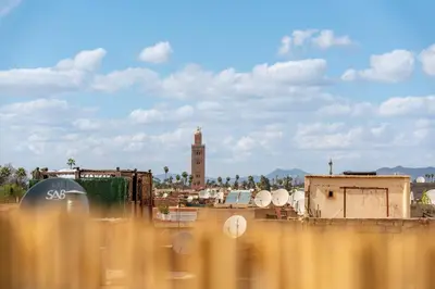 a view of a city with a clock tower in the background at Riad privatif 2 Chambres, Jacuzzi Proche des Palais in Marrakech