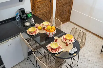 a table with bowls of fruit on top of it at Riad privatif 2 Chambres, Jacuzzi Proche des Palais in Marrakech