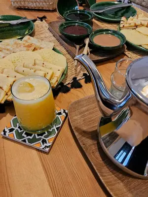 a table with a glass of orange juice and cheese at RIAD AWEL - 3 chambres & jacuzzi au coeur de la Medina in Marrakech
