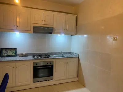 a kitchen with white cabinets and a stove top oven at Cosy gem in the heart of marrakech in Marrakech