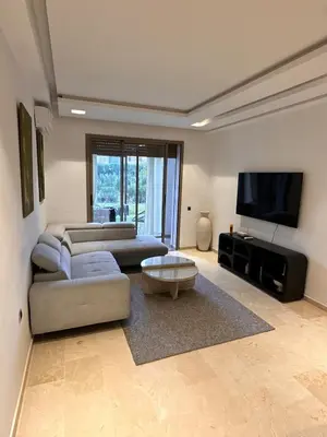 a living room with two couches and a flat screen tv at Prestigia Argane Jubaea Marrakech in Marrakech