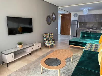 a living room with a green couch and a table at Appartemen luxe in Marrakech