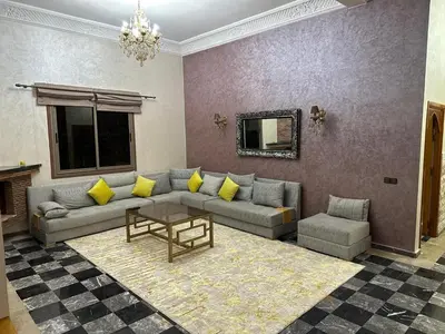 a living room with a couch and a table at Villa haut standig 2000 m2 in Marrakech