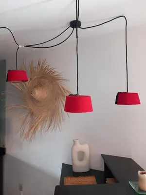 two lights on a wall with a table and a vase at Cosy et confortable in Marrakech