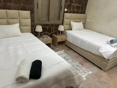 a bedroom with two beds and two tables with lamps at villa ourika in Marrakech