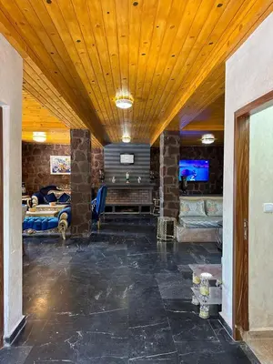 a living room with a large room with a stone wall at villa ourika in Marrakech