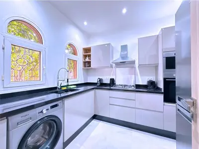 a kitchen with white cabinets and a washing machine at New! Duplex Annakhil , Calme et proximité centre in Marrakech