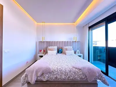 a bedroom with a large bed with pink blankets and pillows at villa Emna Design Contemporain & piscine chauffée in Marrakech