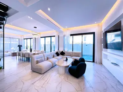 a living room with a couch and a table at villa Emna Design Contemporain & piscine chauffée in Marrakech