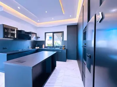 a kitchen with blue cabinets and a black counter top at villa Emna Design Contemporain & piscine chauffée in Marrakech