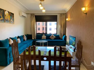 a living room with a blue couch and a table at chic&Calm appartment in gueliz in Marrakech