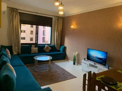 a living room with a blue couch and a television at chic&Calm appartment in gueliz in Marrakech