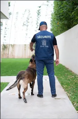a man walking two dogs on a sidewalk at Modern Villa Assia in Marrakech