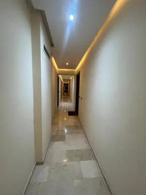 an empty hallway with a white wall and a tile floor at Habiba in Marrakech