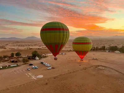 two hot air balloons flying over a parking lot at Riad zineb au cœur de Marrakech &3 Piscines &Jacuzzi & Petit-Déjeuner& parking gratuit in Marrakech