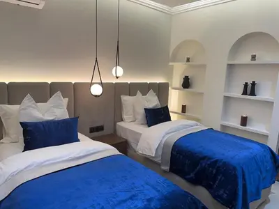 a bedroom with two beds with blue and white sheets at Prestige cocon in Marrakech
