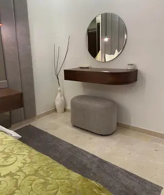 a bedroom with a mirror and a ottoman and a bed at Prestige cocon in Marrakech