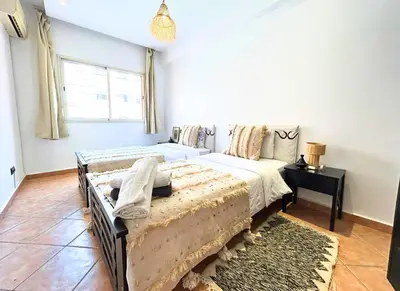 a bedroom with two beds and a window at Perle Au cœur de Gueliz avec Piscine et 100m2 in Marrakech