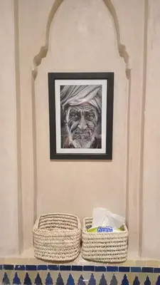 a picture of a man on a wall with two baskets at Coeur de Marrakech Majorelle 2ch Parking in Marrakech