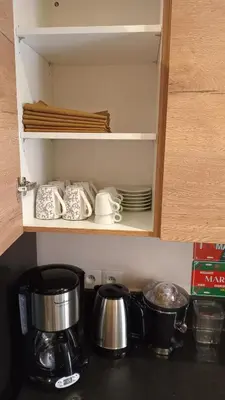a cupboard with dishes and pots and pans in a kitchen at Coeur de Marrakech Majorelle 2ch Parking in Marrakech