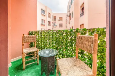 a patio with two chairs and a glass table at Appartement Luxe à Marrakech in Marrakech