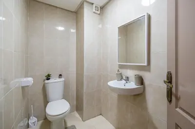 a white bathroom with a toilet and a sink at Appartement Luxe à Marrakech in Marrakech