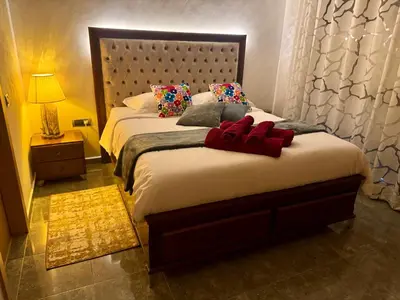 a bedroom with a large bed with red pillows at Marrakech 3 ch piscine et déco artisanale parfait business et famille in Marrakech