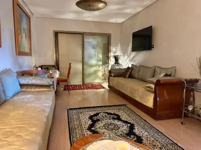 a living room with a couch and a table at Marrakech 3 ch piscine et déco artisanale parfait business et famille in Marrakech