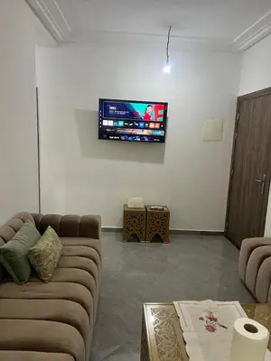 a living room with a couch and a tv on the wall at Modern Apartment in Great Location of Marrakesh in Marrakech