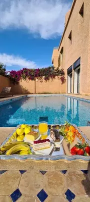 a tray of food on a table next to a swimming pool at Villa marrakech in Marrakech