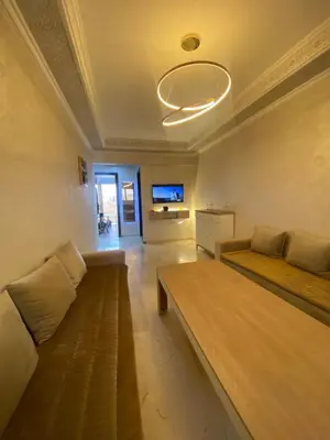 a living room with a couch and a flat screen tv at Homesweethome in Marrakech