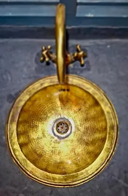 a close up of a gold sink with a faucet at Riad Dar el Hachmia - Central private Riad, Air cond, heated pool and Hammam in Marrakech
