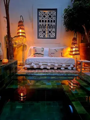 a bedroom with a bed and a pool of water at Riad Dar el Hachmia - Central private Riad, Air cond, heated pool and Hammam in Marrakech