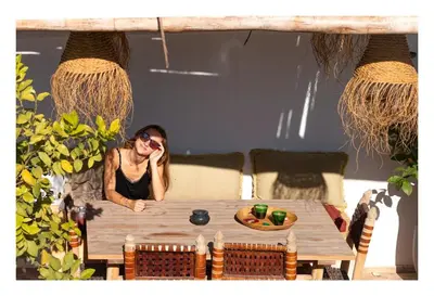 a woman sitting at a table in a room at Riad Dar el Hachmia - Central private Riad, Air cond, heated pool and Hammam in Marrakech