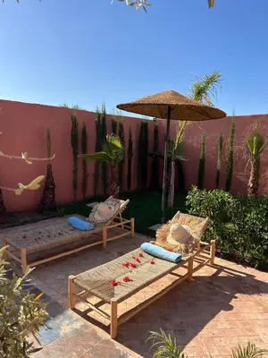 a patio with two chairs and an umbrella at Villa Familiale avec Piscine Privée à Marrakech in Marrakech