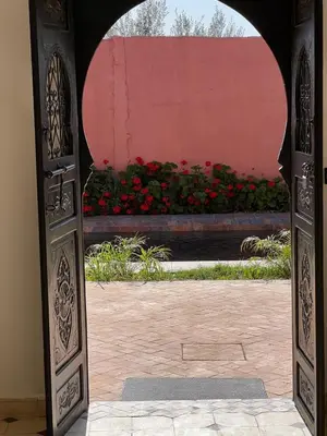 an open door to a garden with red flowers at Villa Familiale avec Piscine Privée à Marrakech in Marrakech