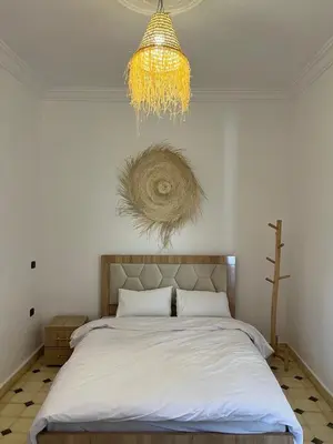 a bedroom with a large bed and a chandelier at Villa Familiale avec Piscine Privée à Marrakech in Marrakech