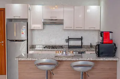 a kitchen with a counter with two stools in it at pearl garden in Marrakech