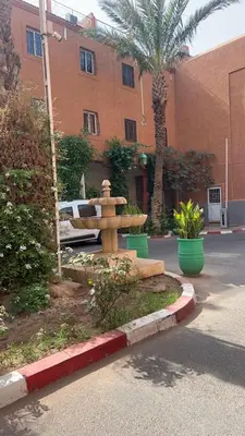 a fountain in a courtyard in front of a building at Riad Marrakech in Marrakech