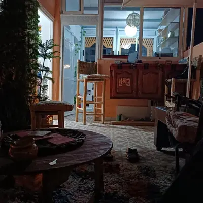 a living room with a table and a couch and a kitchen at Dar Bellaji l Bed & Breakfast in Medina l Rooftop Koutoubia in Marrakech