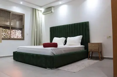 a bedroom with a large bed with a green headboard at appartement 3 chambres gueliz only families in Marrakech