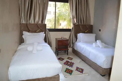 a bedroom with two beds and a window at Appartement avec piscine in Marrakech