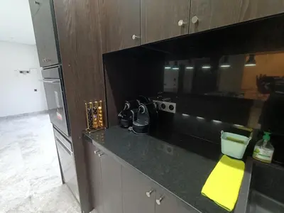 a kitchen with a black counter top with a yellow folder at Luxurious villa in Marrakech