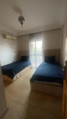 a bedroom with two beds and a window at Appartement sur Guéliz in Marrakech