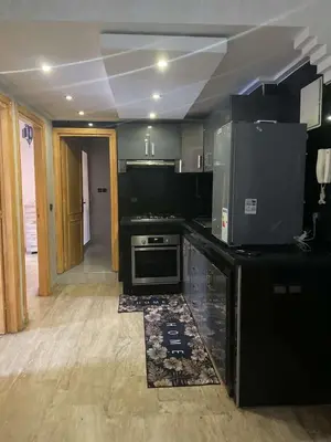 a kitchen with black counters and a stove top oven at Appartement sur Guéliz in Marrakech