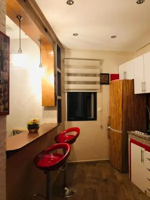 a kitchen with two red stools at a counter at Apartment Marrakech in Marrakech