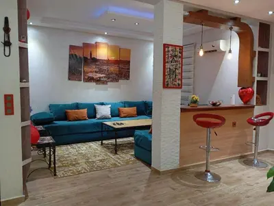 a living room with a blue couch and a kitchen at Apartment Marrakech in Marrakech