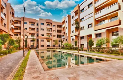 an apartment building with a pool in front of it at Bonheur partagé 2 in Marrakech