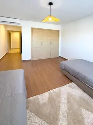 a bedroom with a bed and wooden floors at Appartement tout confort à Marrakech avec Piscine et Capacité 4 Personnes in Marrakech